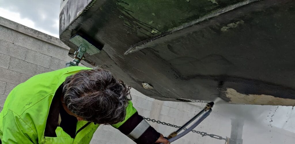 Carena di imbarcazione durante lavori di sabbiatura